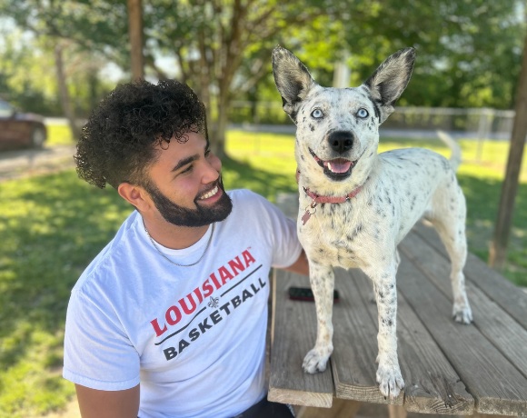 Happy volunteer and smiling white dog 