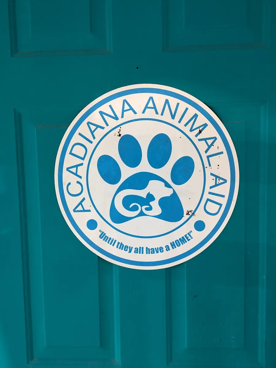 Teal door at the shelter, with circular shelter sign.